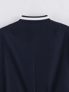 Detailed close-up of navy blue jacket with white striped ribbed collar and neck texture