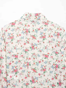 Detail shot of vintage floral print collar on breathable cream white summer shirt