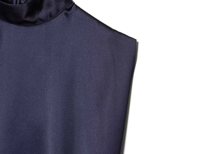 Detailed view of high neck navy satin dress fabric texture and seamless sleeveless cut