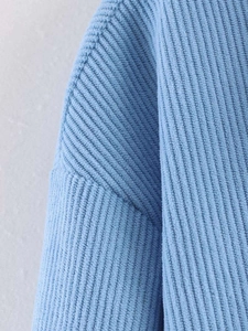 Detailed macro view of light blue ribbed knit texture and soft fabric on the casual top