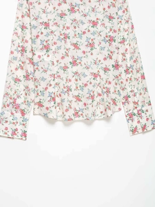 Detailed close-up of floral print fabric on women's long sleeve shirt with rose pattern