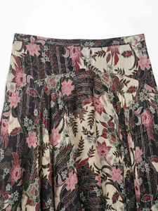 Détail de la jupe à fleurs avec des fils métalliques argentés et un tissu léger