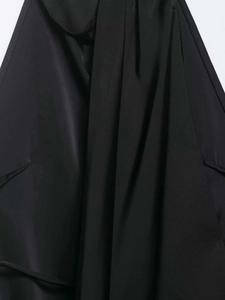 Détail du tissu satiné noir montrant la texture lisse et les coutures de la robe dos nu