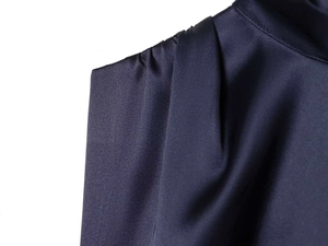 Close-up of dark navy satin mini dress featuring pleated shoulder and mock neck details