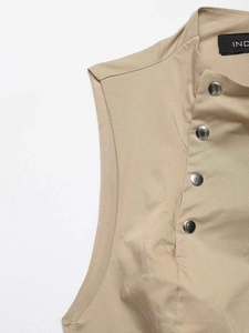 Detail einer khakifarbenen ärmellosen Weste mit seitlichen Druckknöpfen und Stehkragen
