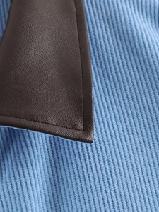 Detail of light blue corduroy fabric with dark brown faux leather collar stitching