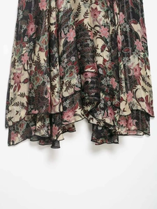 Détail d'une jupe florale vintage avec rayures métalliques argentées et ourlet ondulé
