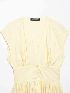 Détail de la robe sans manches jaune pâle avec col en V, plis et boutons à la taille