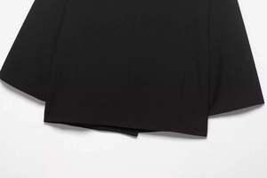Close-up of the woven fabric texture and hem stitching on a black blazer jacket
