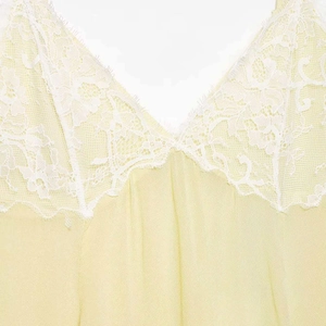 Pale yellow V-neck dress featuring delicate white eyelash lace trim details