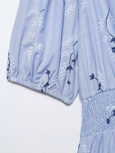 Detail of light blue floral embroidery and smocking texture on summer dress sleeves