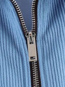 Close-up of blue corduroy texture and silver metal zipper detail on casual jacket