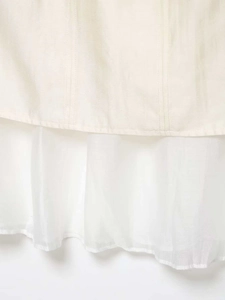 Détail de la jupe midi blanche montrant la texture lin-coton et coutures en mousseline