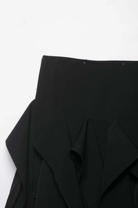 Vue détaillée de la jupe noire taille haute avec volants superposés et tissu lisse