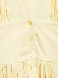 Vue détaillée d'une robe crème à col en V avec boutons et texture plissée délicate