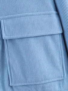 Close-up of blue corduroy fabric texture and pocket detail on the casual jacket