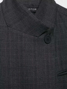 Close-up of charcoal grey plaid blazer with fine texture and black button detail
