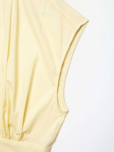 Gros plan détaillé sur les coutures de l'emmanchure sans manches et les plis de la robe jaune
