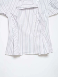 Detail of blue striped poplin shirt featuring asymmetrical buttons and peplum waist design