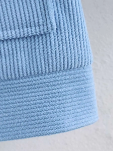 Detailed macro view of sky blue corduroy texture and high-quality stitching on jacket