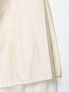 Vue détaillée de l'ourlet d'une jupe midi crème montrant la texture du coton tissé