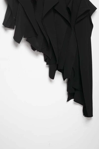 Détail de l'ourlet à volants asymétriques multicouches sur une jupe noire élégante
