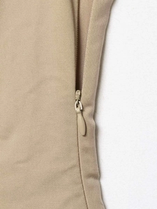 Detailaufnahme eines beigen ärmellosen Tops mit nahtlosem verdecktem Seitenreißverschluss