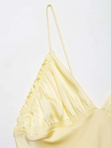 Détail d'une robe midi en satin jaune clair avec décolleté à volants et corsage froncé