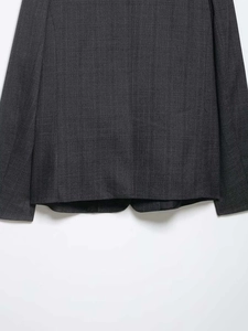 Detail shot of dark grey pinstripe fabric texture and sleek black lining on a blazer