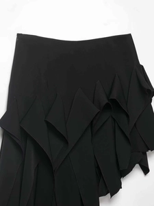 Détail de la jupe noire asymétrique avec ourlet à volants multicouches et texture tissée