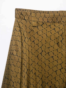 Detailed macro view of snake print fabric pattern and waistband stitching on trousers