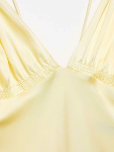 Détails de la robe en satin jaune clair avec col en V et taille froncée par smocks