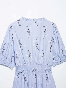 Detail of light blue floral dress showing smocked waist and puffed short sleeves