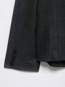Detail of dark grey blazer sleeve with four buttons and fine striped fabric texture