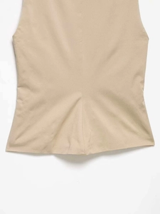 Nahaufnahme des beigen ärmellosen Tops mit glatter Textur und sauberen Saumdetails