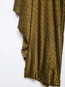 Detailed macro shot of olive green fabric with black T-letter pattern and button detail