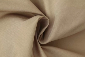 Close-up of khaki double-breasted trench coat showing twill weave fabric texture