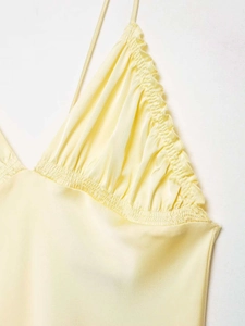 Détail du caraco en satin jaune clair avec décolleté en V et bordure plissée à volants