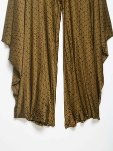 Detailed view of dark olive wide leg pants with black geometric print and button accents