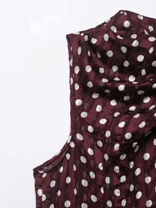 Gros plan sur tissu mousseline bordeaux à pois avec texture plissée et fini semi-transparent