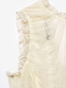 Detailed view of the ivory lace trim and ruffle edge on this sleeveless V-neck blouse