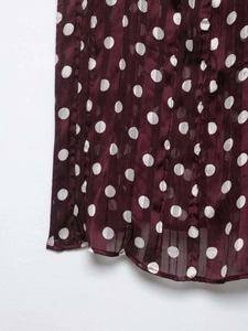 Détail du tissu en mousseline bordeaux à pois avec une texture légère semi-transparente