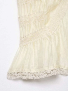 Detailed macro view of cream-colored tiered lace trim and pleated fabric texture