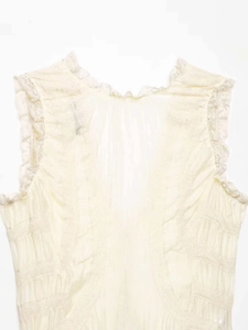 Detail of V-neck lace trim and pleated sheer fabric on a cream sleeveless top