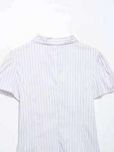 Detail showing high-quality pinstripe poplin fabric and pleated puff sleeves of the shirt
