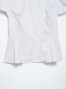 Close-up of blue vertical striped poplin shirt featuring button-down front and peplum hem
