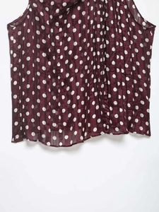 Détail du haut sans manches bordeaux à pois avec texture plissée en mousseline