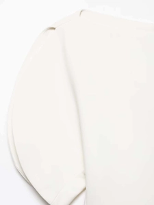 Detailed macro view of the shoulder stitching and puff sleeve of this off-shoulder shirt