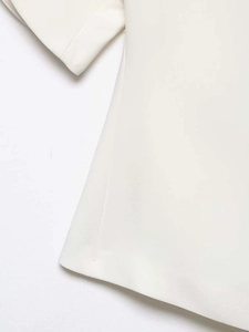 Detail view of ivory puff sleeve blouse showing fabric texture and neat side stitching