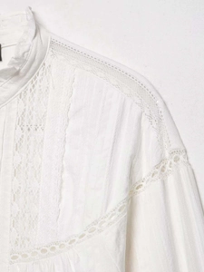 Detailed close-up of white lace blouse featuring ruffle stand collar and intricate embroidery